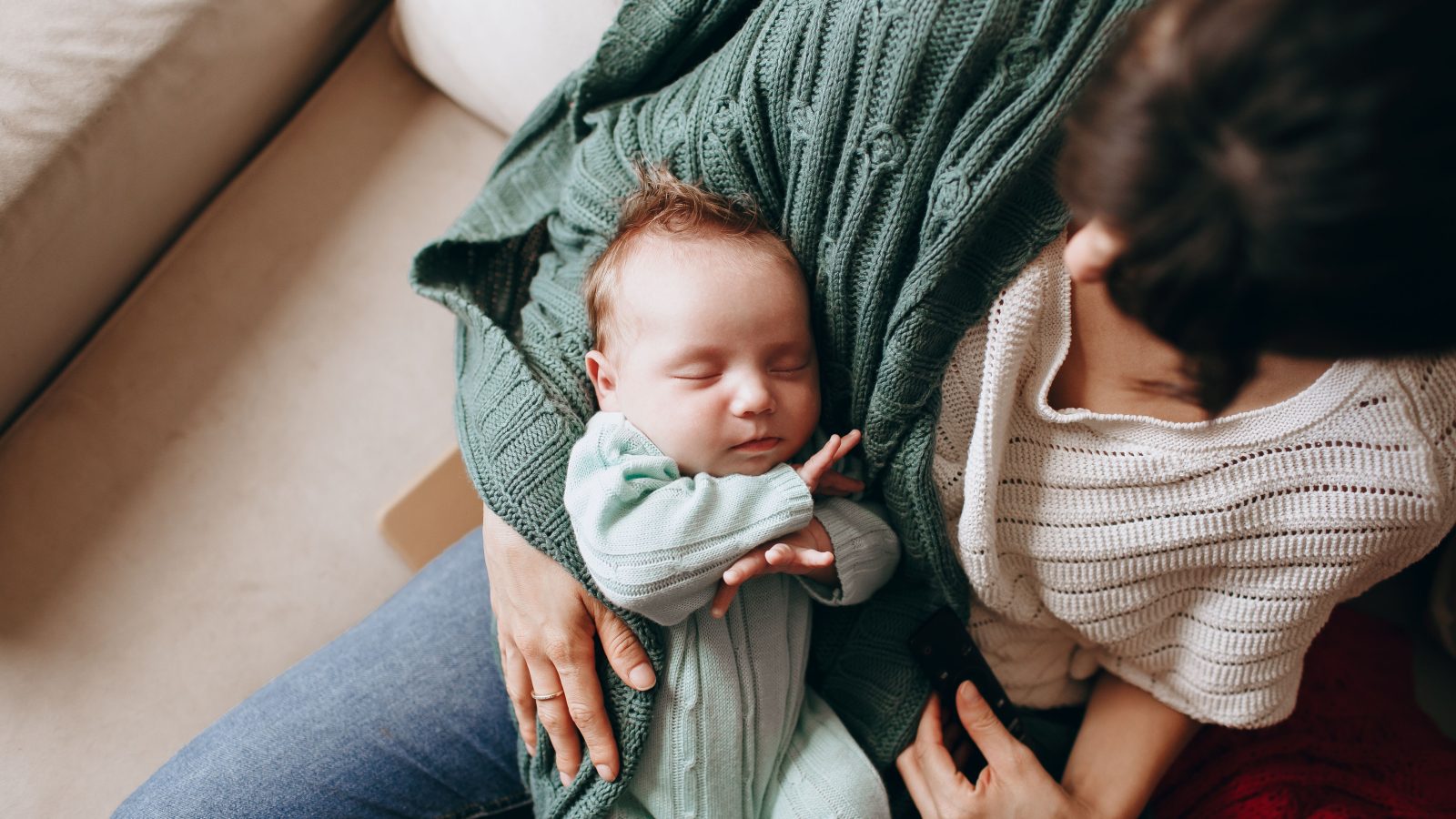 Mère tenant son nouveau-né endormi avec tendresse