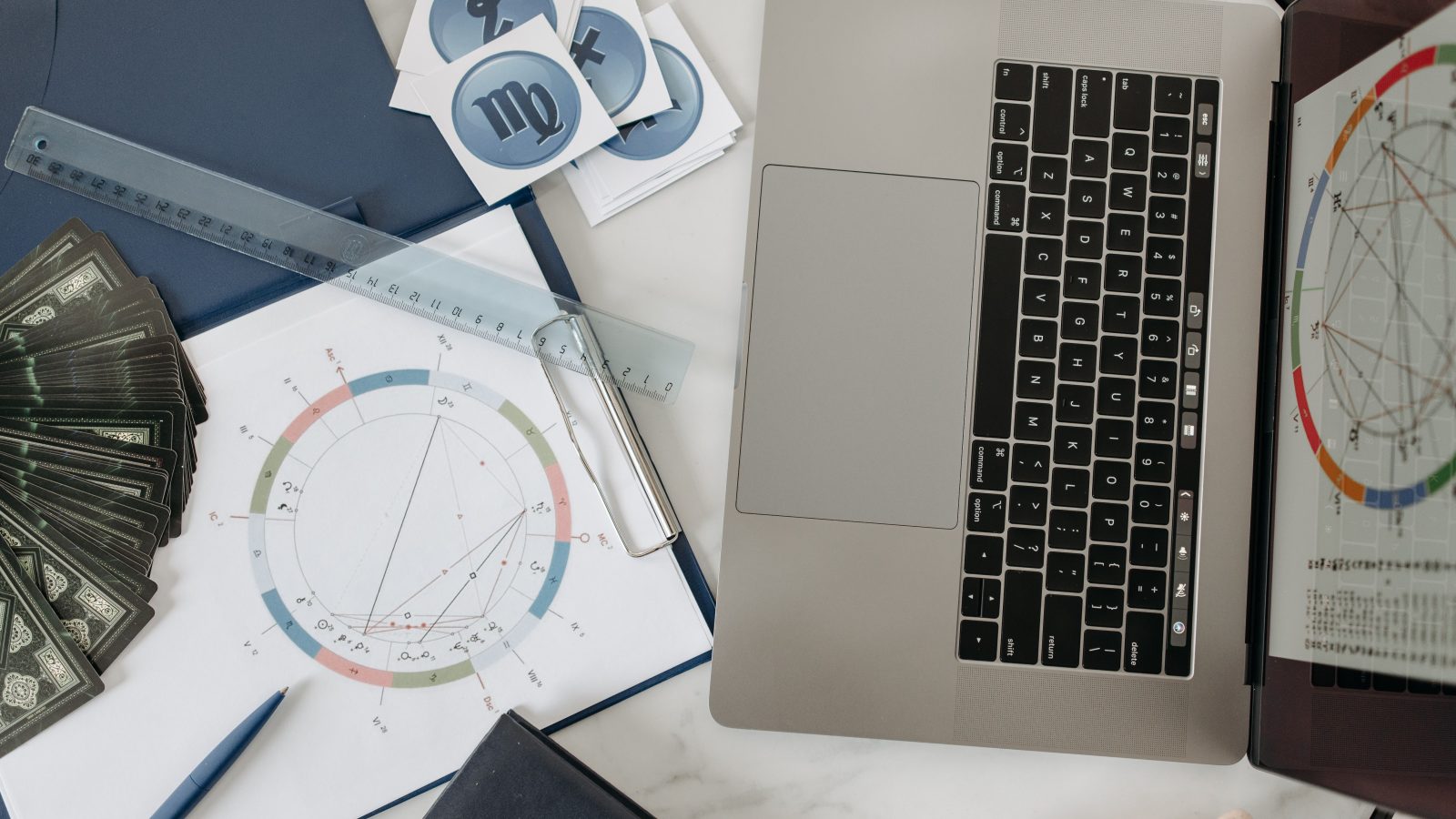 Tableau astrologique, ordinateur et cartes de tarot sur bureau