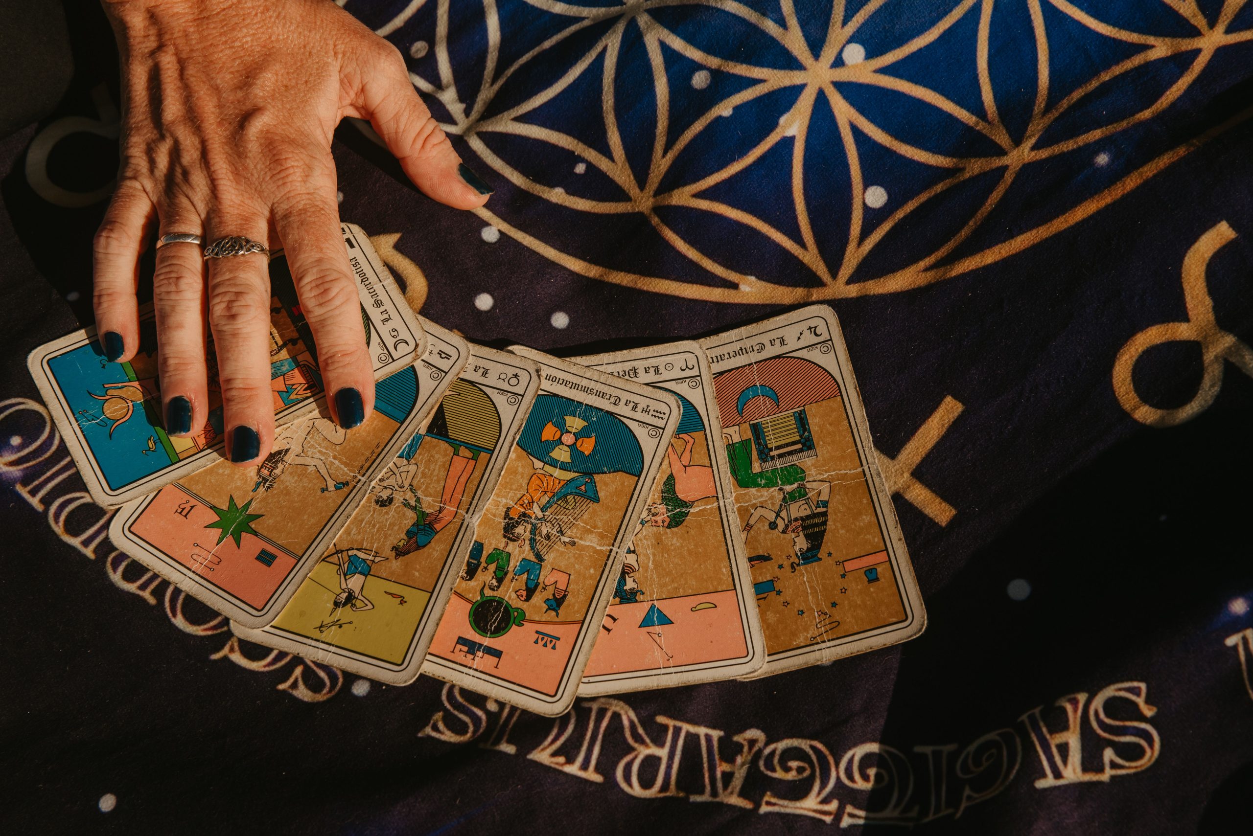 Main disposant des cartes de tarot sur tissu étoilé